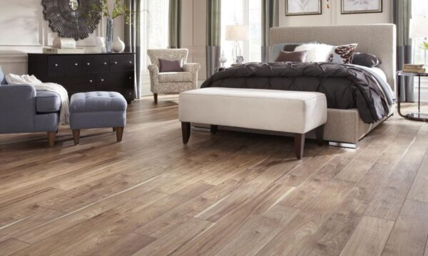 Cozy bedroom featuring a stylish bed, elegant furniture, and wooden flooring.
